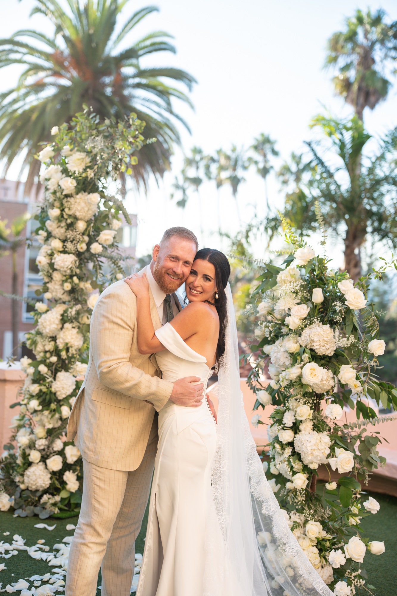 Groom and bride in front of flowers