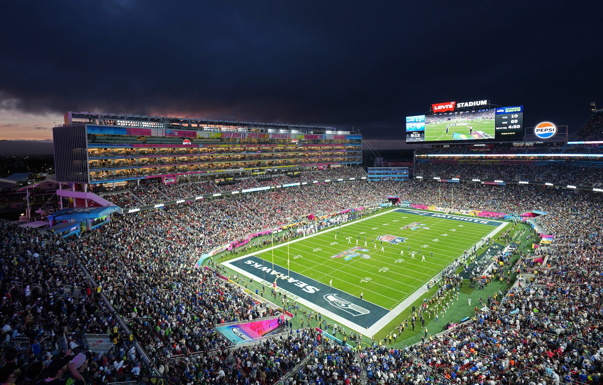 Panoramic night view of a packed Super Bowl stadium and illuminated field.