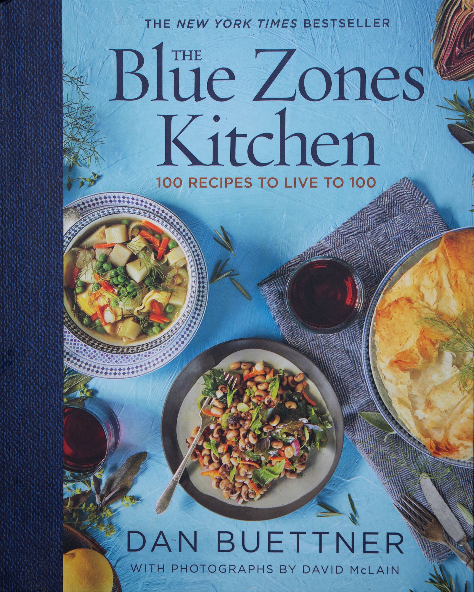 Book cover: &ldquo;The Blue Zones Kitchen&mdash;100 Recipes to Live to 100&rdquo; by Dan Buettner with overhead dishes.